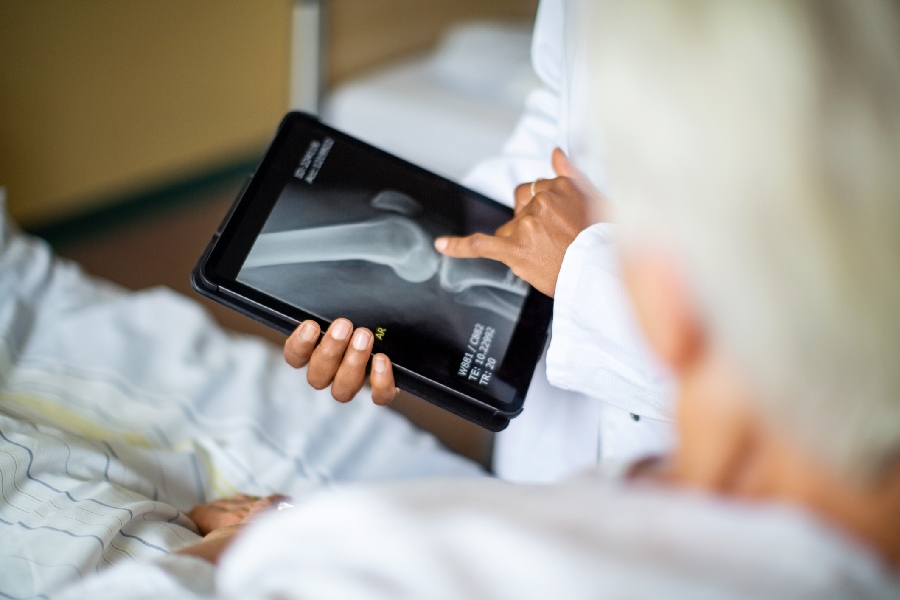 A doctor using a medical device to show a patient an x-ray