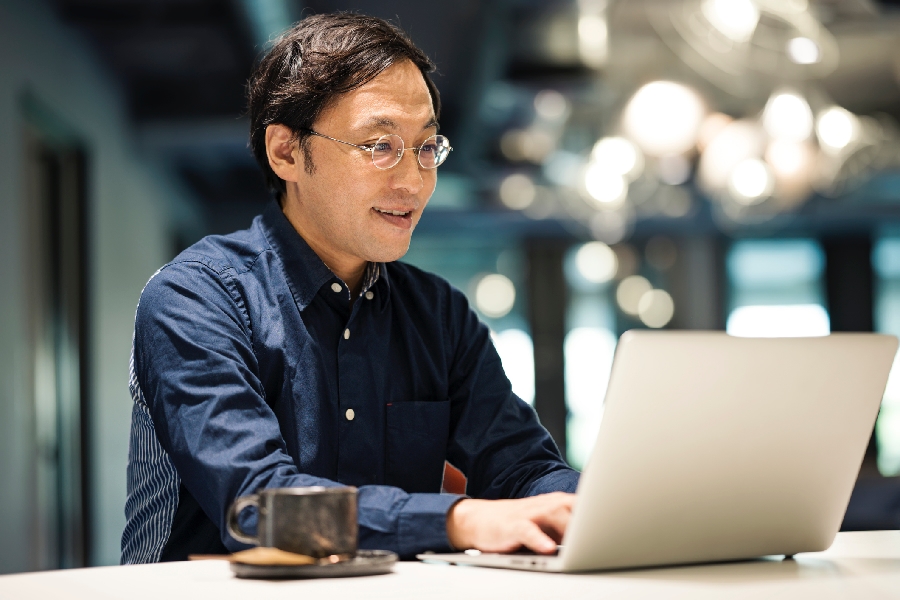 A man on a laptop drinking coffee