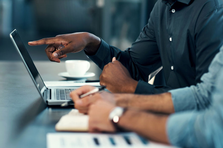 Cybersecurity experts working on laptops together