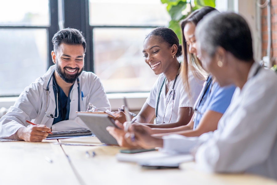 A group of doctors collaborating on laptops around a table