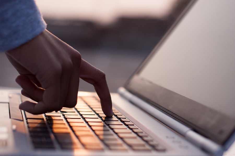 A hand touching a laptop