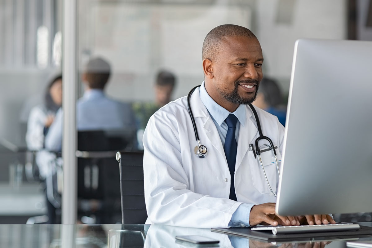 A doctor with a stethoscope working on a computer